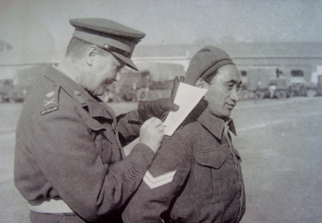 Cpl. Potene happily helps General Freyberg..