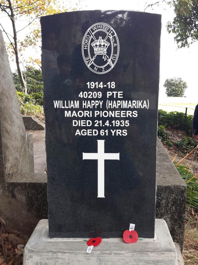 Black marble headstone of Wirina Hapimarika - known as William Happy with dates and name carved in white over a white cross. 