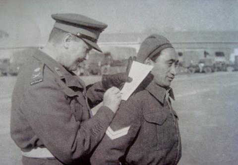 Cpl. Potene happily helps General Freyberg..