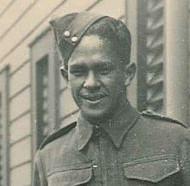 Head and shoulders of a soilder in front of a wooden building
