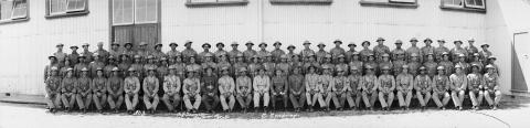 Many soliders sitting in three rows.